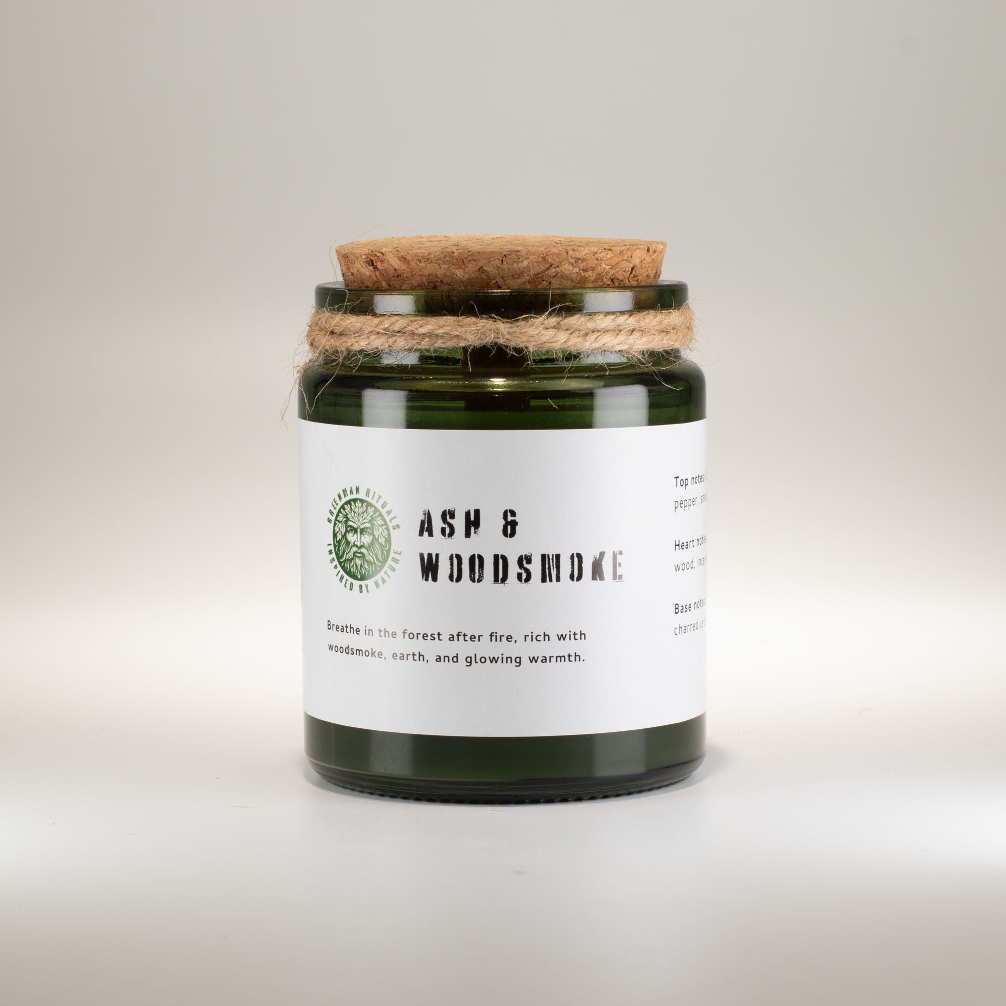 Candle jar with cork lid and label on a light gray background