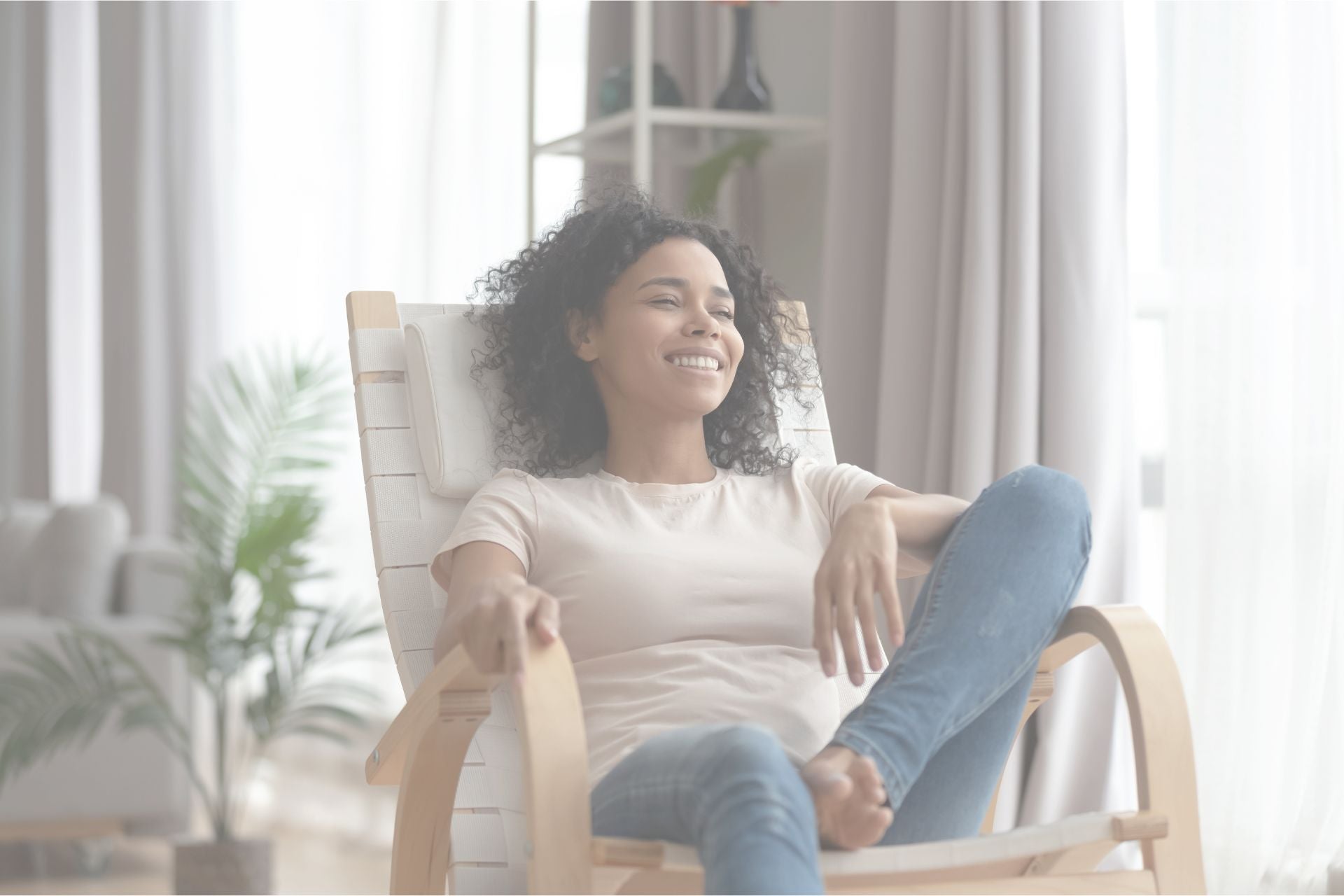 Woman sitting in a rocking chair in a bright room with plants and furniture.