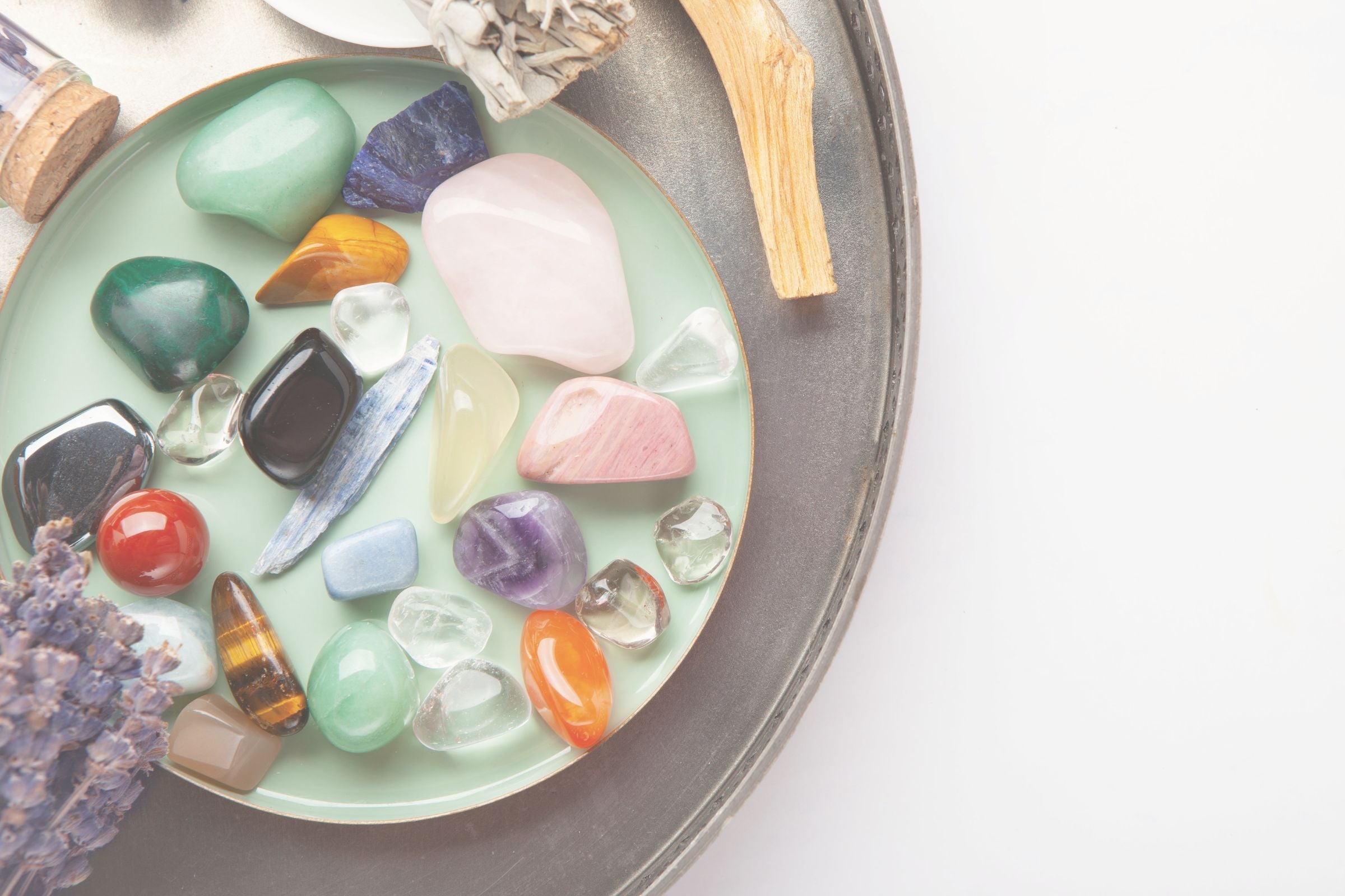 Colorful crystals on a round tray with a white background
