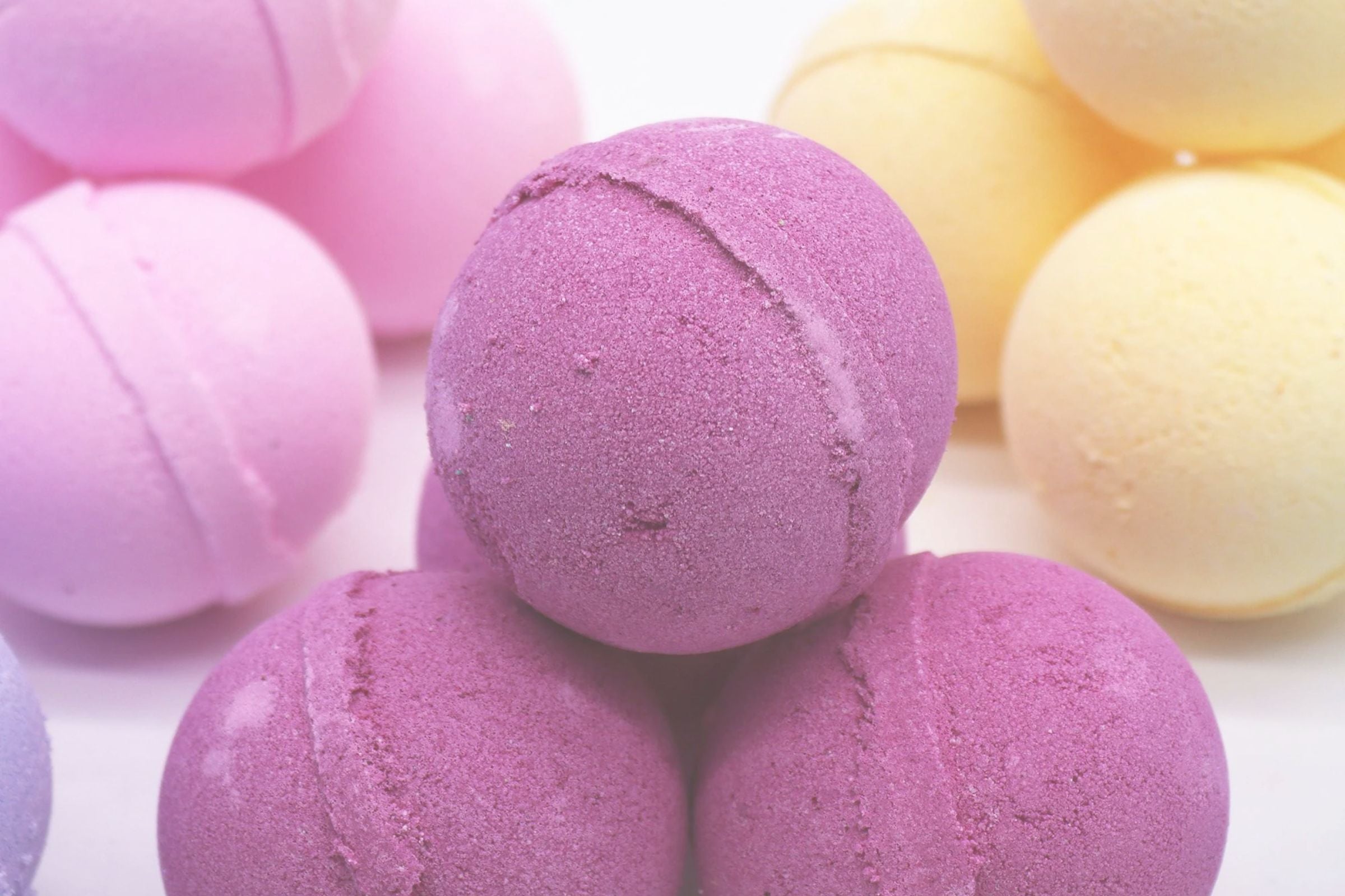 Purple and yellow bath bombs on a white background