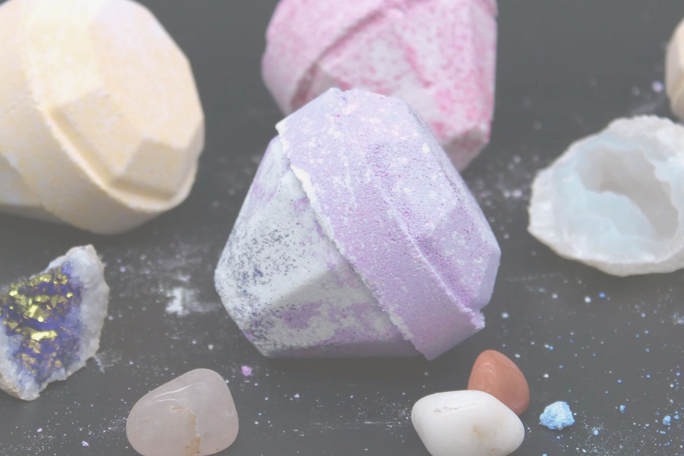 Colourful bath bombs on a dark surface
