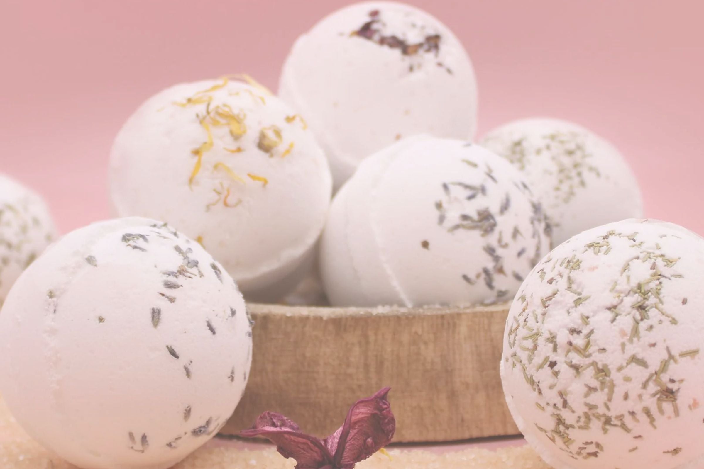 Bath bombs with decorative elements on a pink background