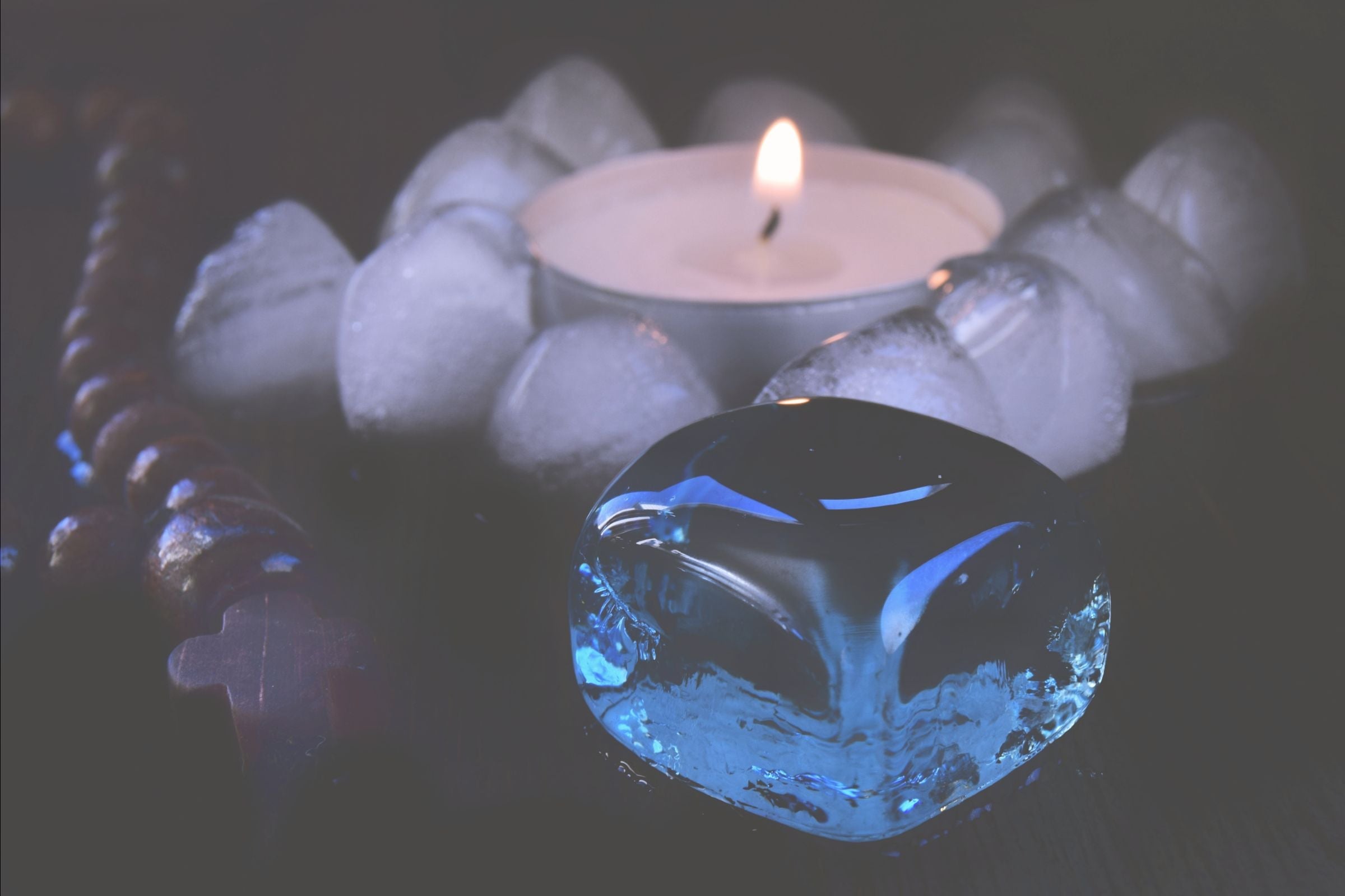 Gemstones reflecting a candle in a dark setting