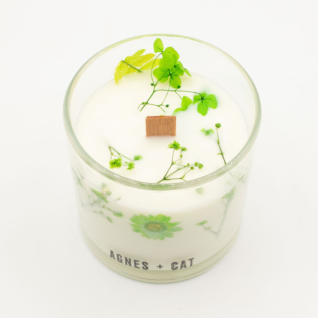 Candle in a glass jar with greenery and &