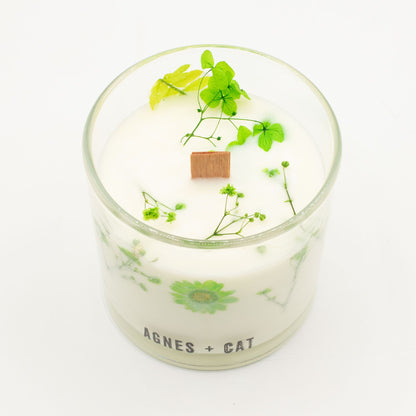 Candle in a glass jar with greenery and &