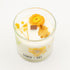 Candle with dried flowers in a glass container on a white background