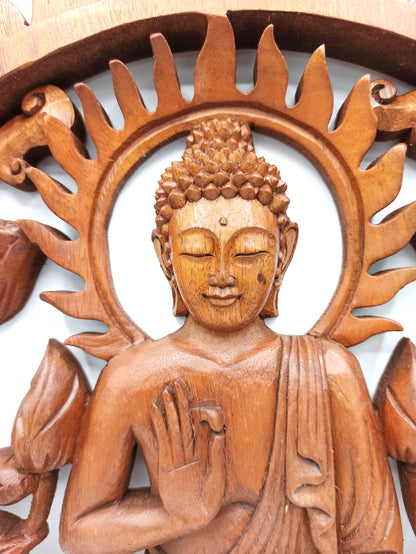 Wooden carving of a seated Buddha figure with lotus flowers and sun-like design.