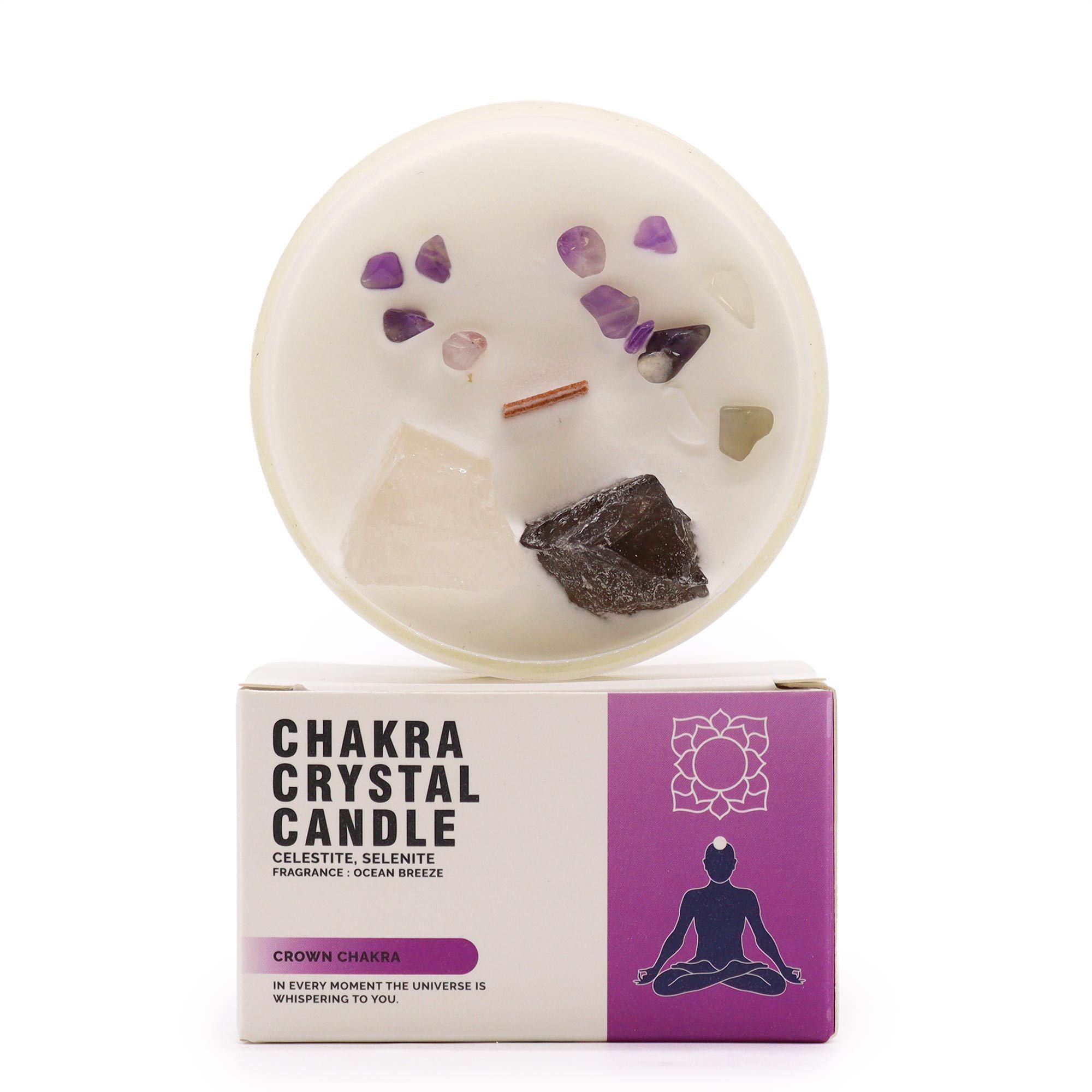 Chakra crystal candle with decorative stones on top of its packaging box.