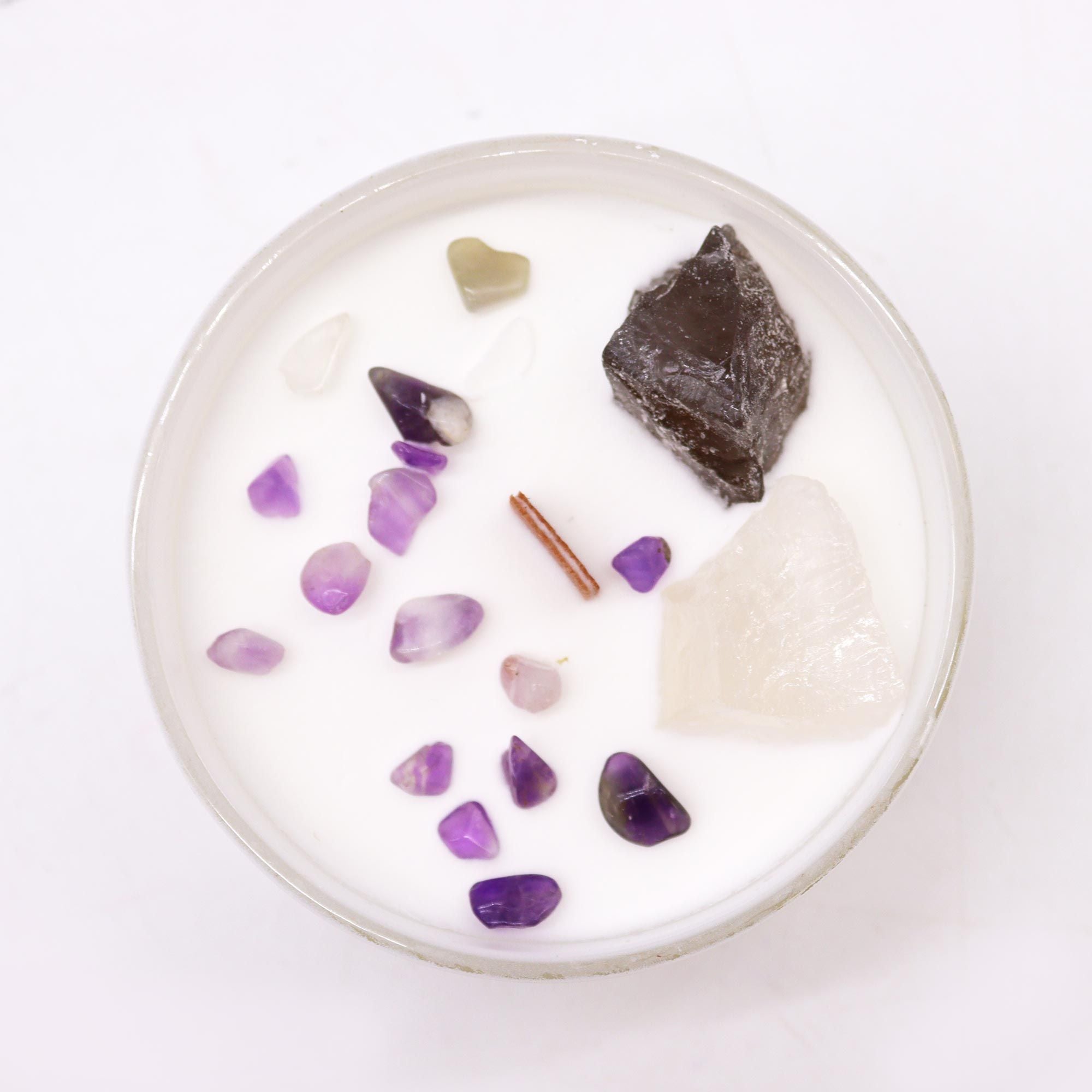 Candle with embedded stones on a white background