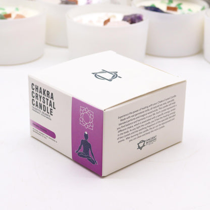 Box of Chakra Crystal Candle on a white surface with blurred candles in the background