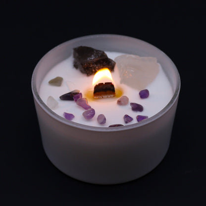 Candle with embedded stones on a black background