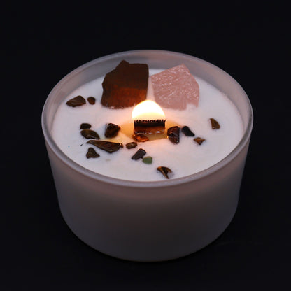 Candle with decorative stones on a black background