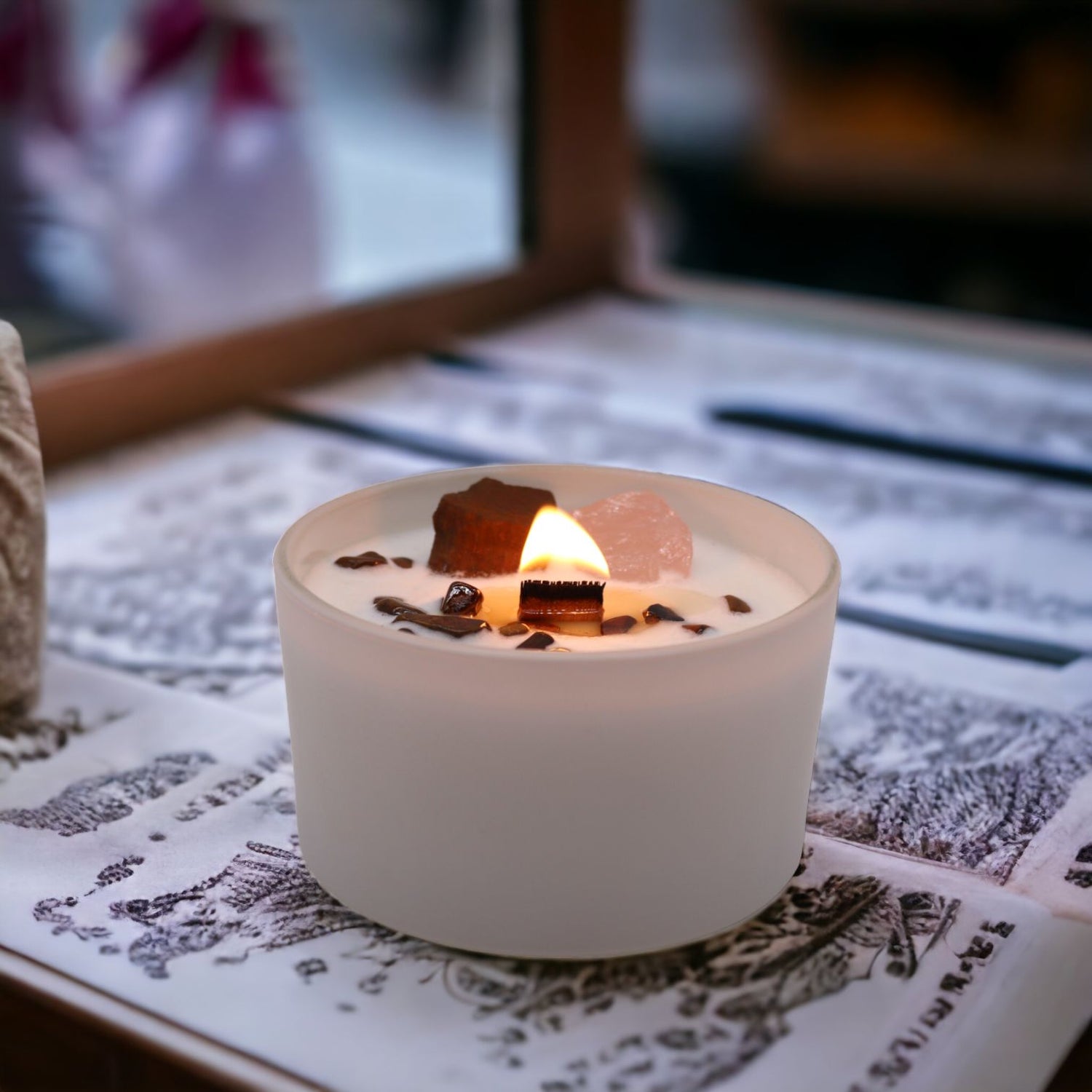 Candle in a white holder with decorative elements on a textured surface