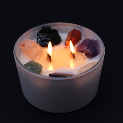 Candle with colourful stones on a black background