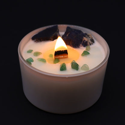 Candle with green stones on a black background