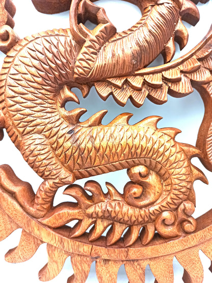 Close-up of a detailed wooden dragon carving on a white background