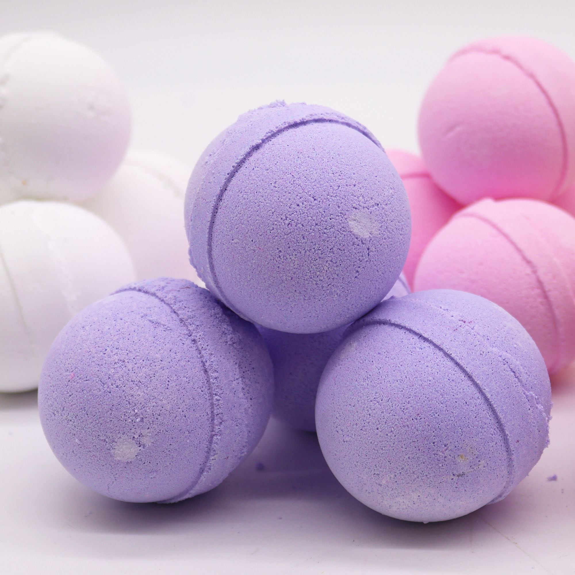 Purple and pink bath bombs on a white background