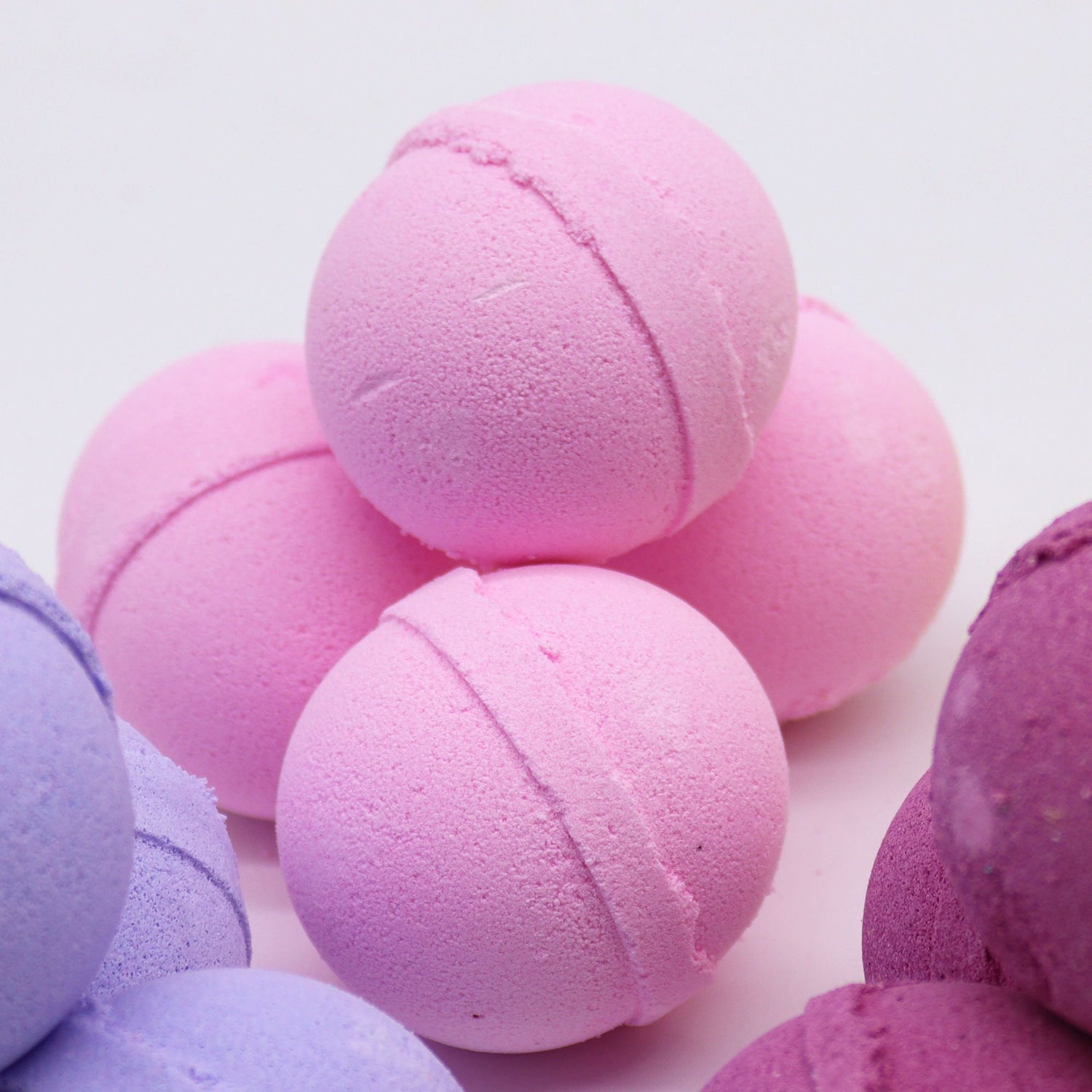 Pink and purple bath bombs on a light pink background