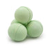 Three green bath bombs stacked on a white background