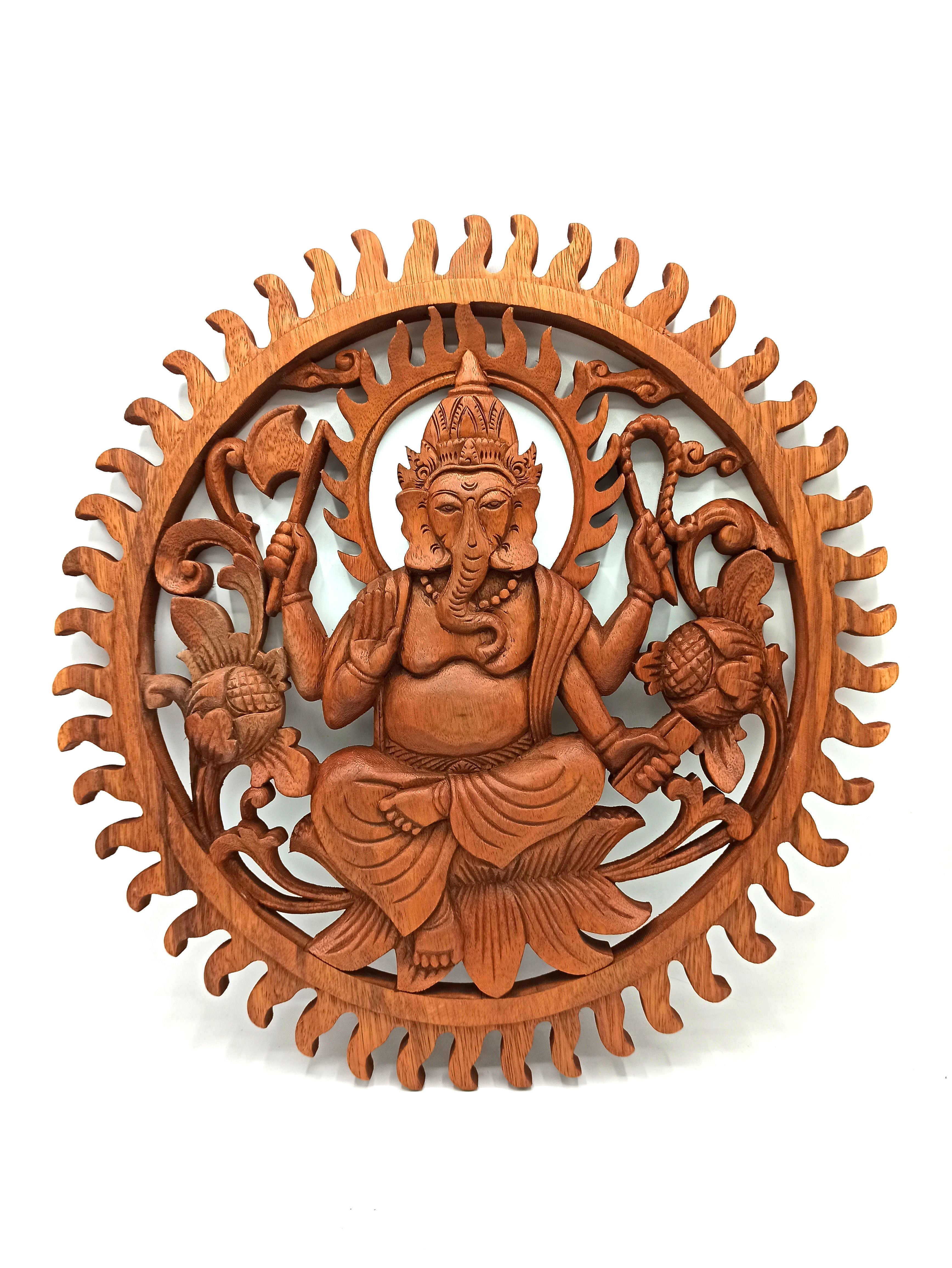 Wooden wall art depicting a seated figure with intricate carvings on a white background