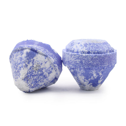 Two blue and white speckled bath bombs on a white background