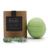 Green bath bomb with brown box and gemstones on a white background
