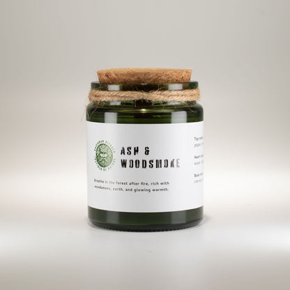 Candle jar with cork lid and label on a light gray background