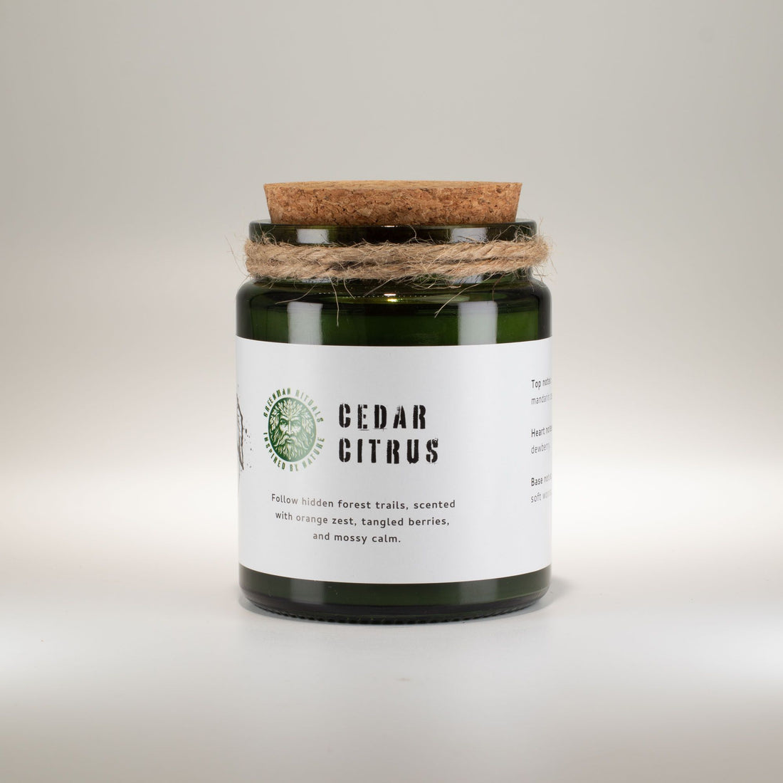 Candle jar with cork lid and white label on a light gray background