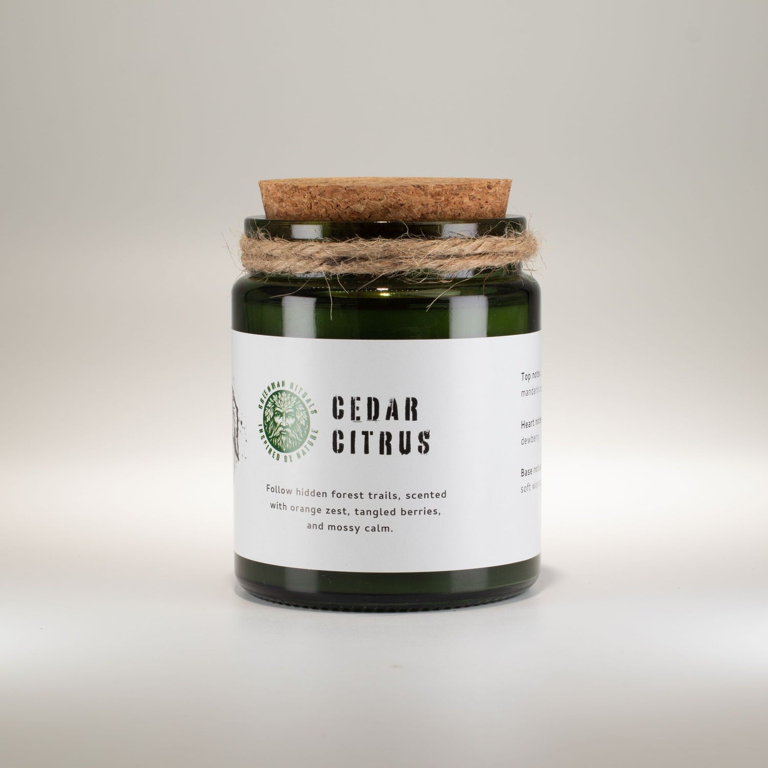 Candle jar with cork lid and white label on a light gray background