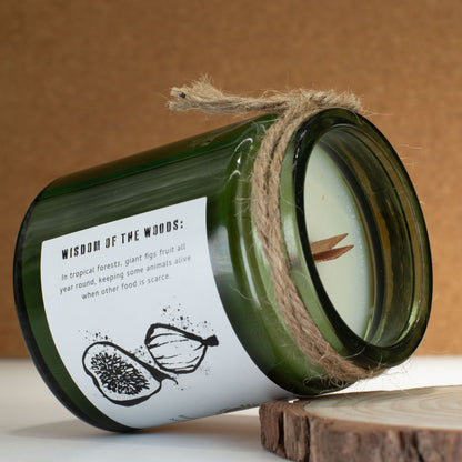 Candle in a green bottle with a label and twine, on a wooden surface with a brown background