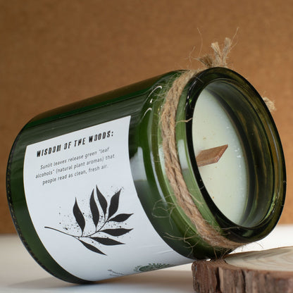 Green candle jar with a label on a wooden surface