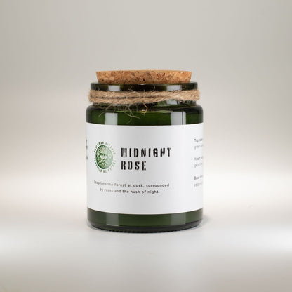 Candle in a green jar with a cork lid on a light gray background