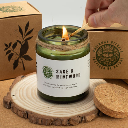 Sage and mintwood candle being lit with a wooden coaster and box in the background