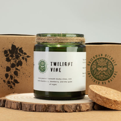 Green candle jar with label on a wooden surface, surrounded by natural elements.