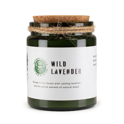 Candle in a green jar with a cork lid on a white background