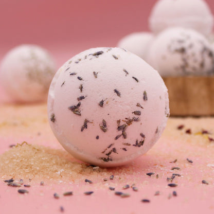 Bath bomb with lavender petals on a pink surface
