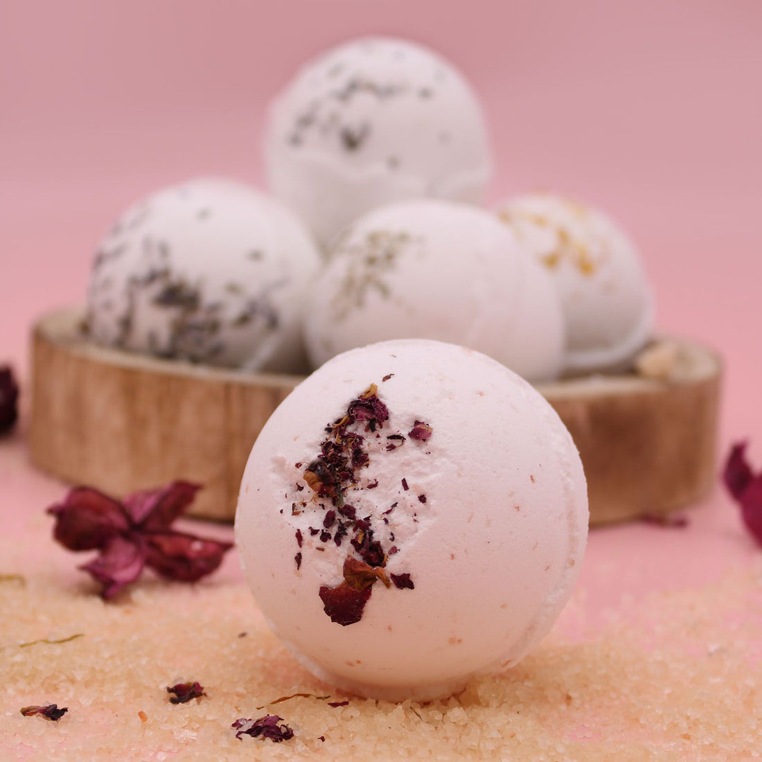 Bath bombs with natural ingredients on a pink background
