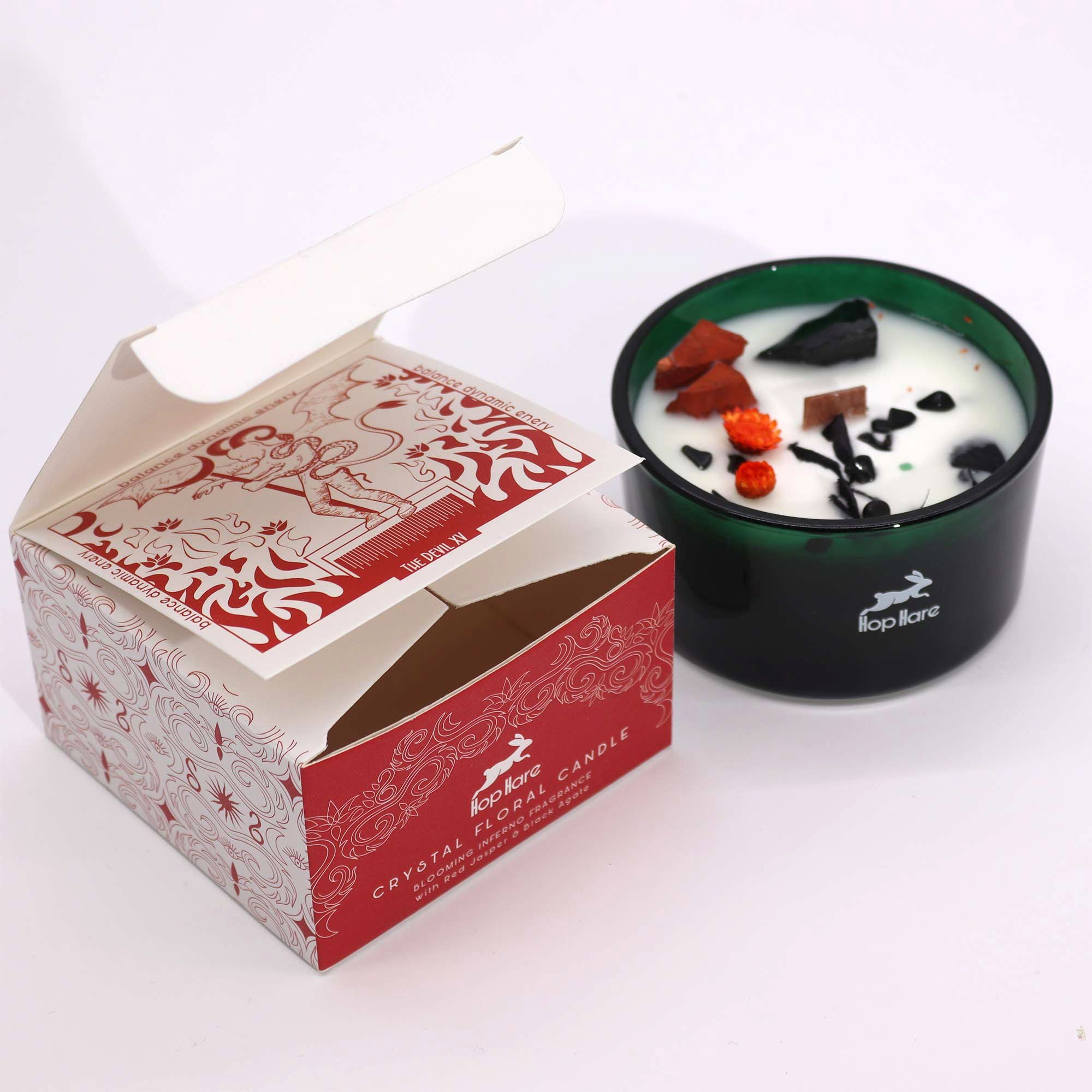 Candle with decorative elements in a branded box on a white background
