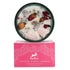 Candle in dark green jar with rose quartz crystals and dried rose petals on soy wax.