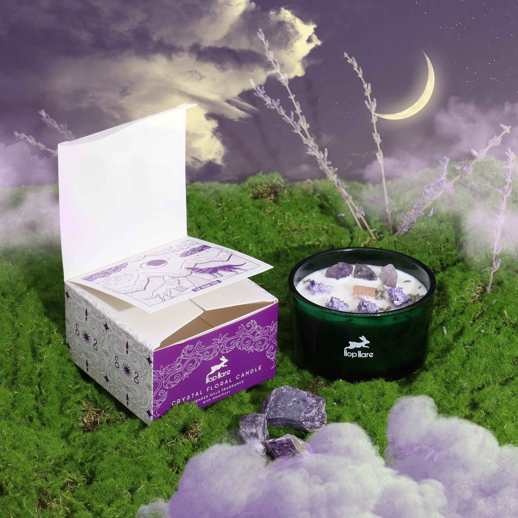 Crystal filled candle with packaging on a grassy field under a moonlit sky