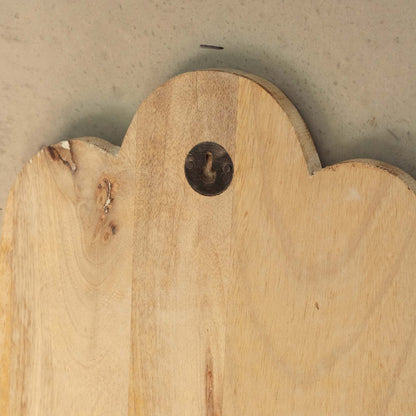 Reverse of a wooden plaque with a decorative edge and metal hanger on a neutral background
