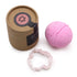 Pink bath bomb with a brown cardboard box and a crystal bracelet on a white background