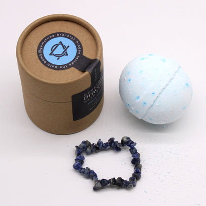 Brown cardboard tube box with a bracelet and bath bomb on a white background