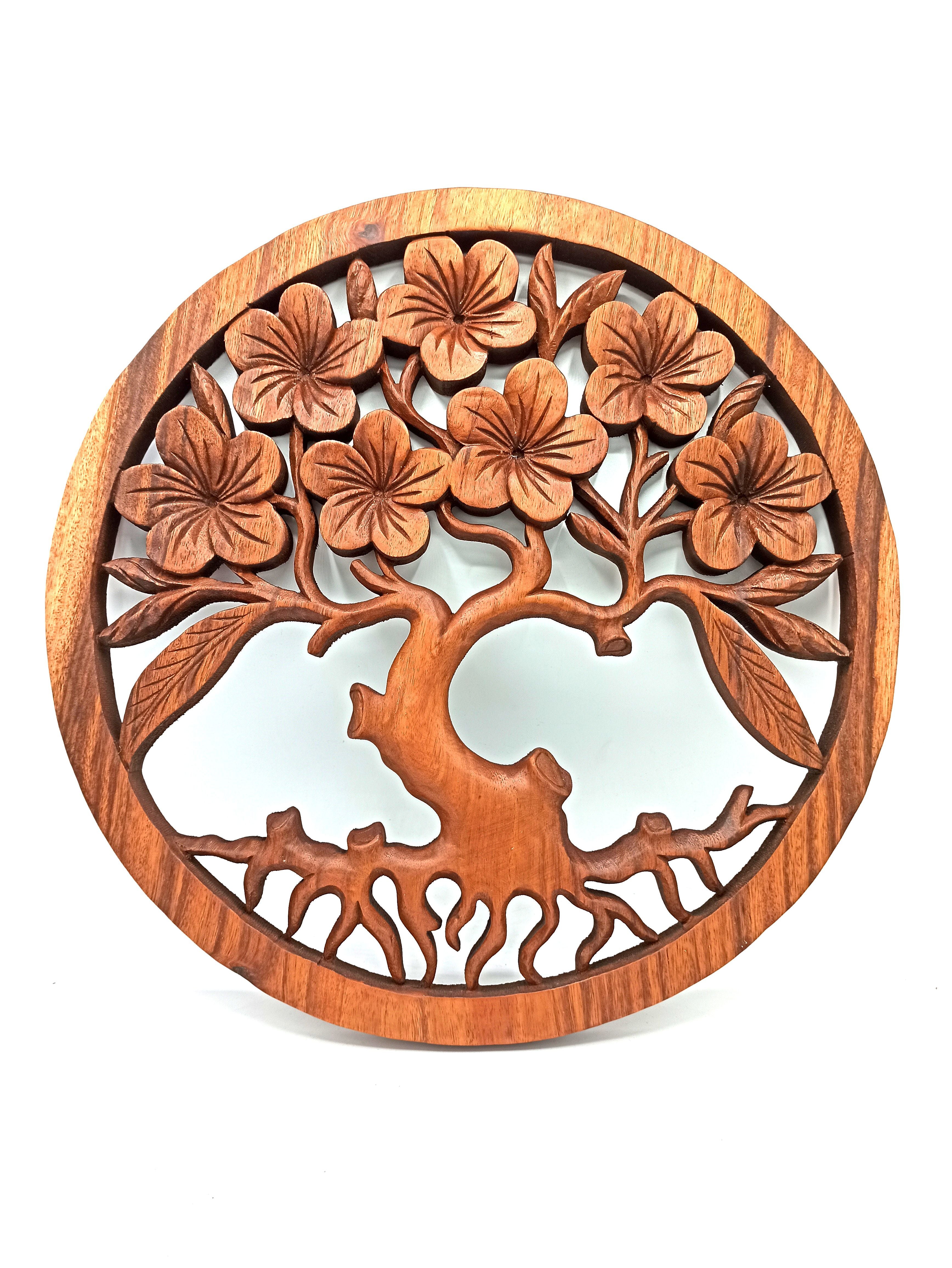 Wooden wall art with floral design on a white background