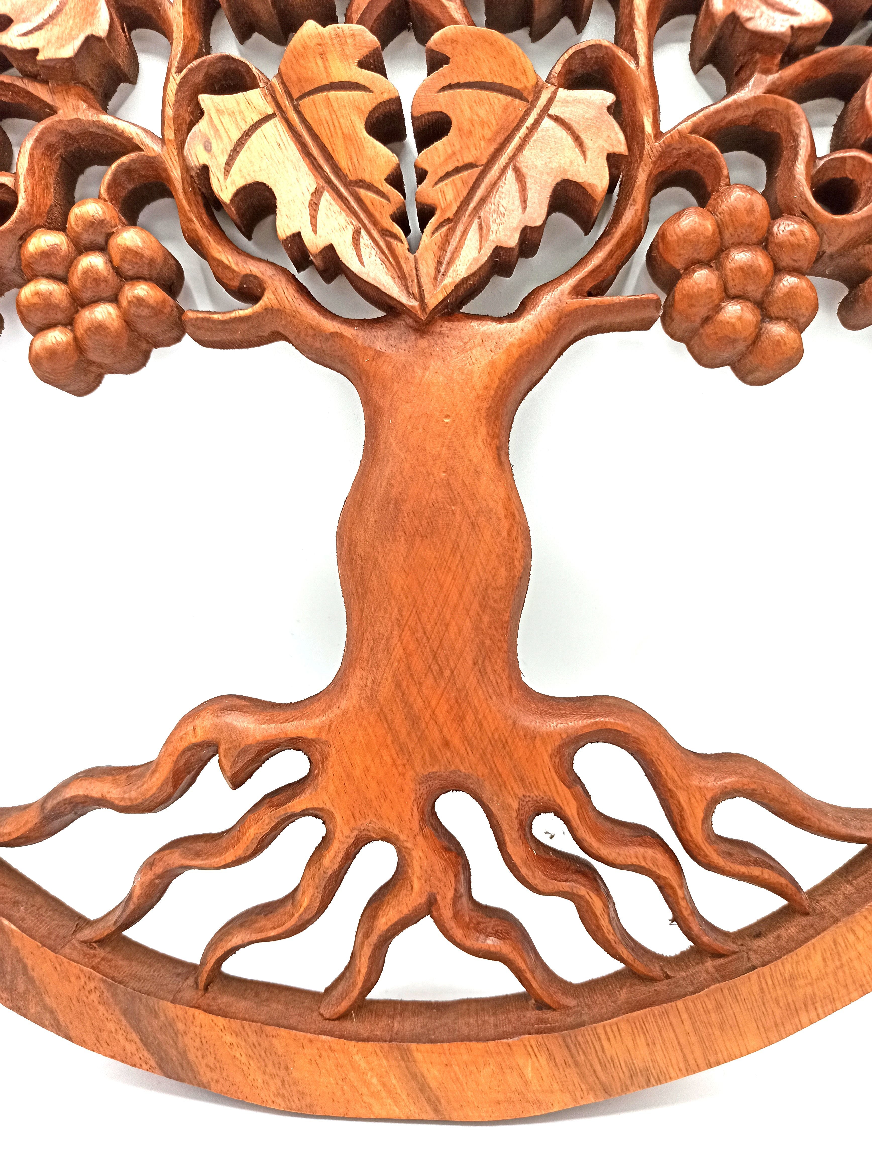Wooden tree of life wall art with leaves and flowers on a white background