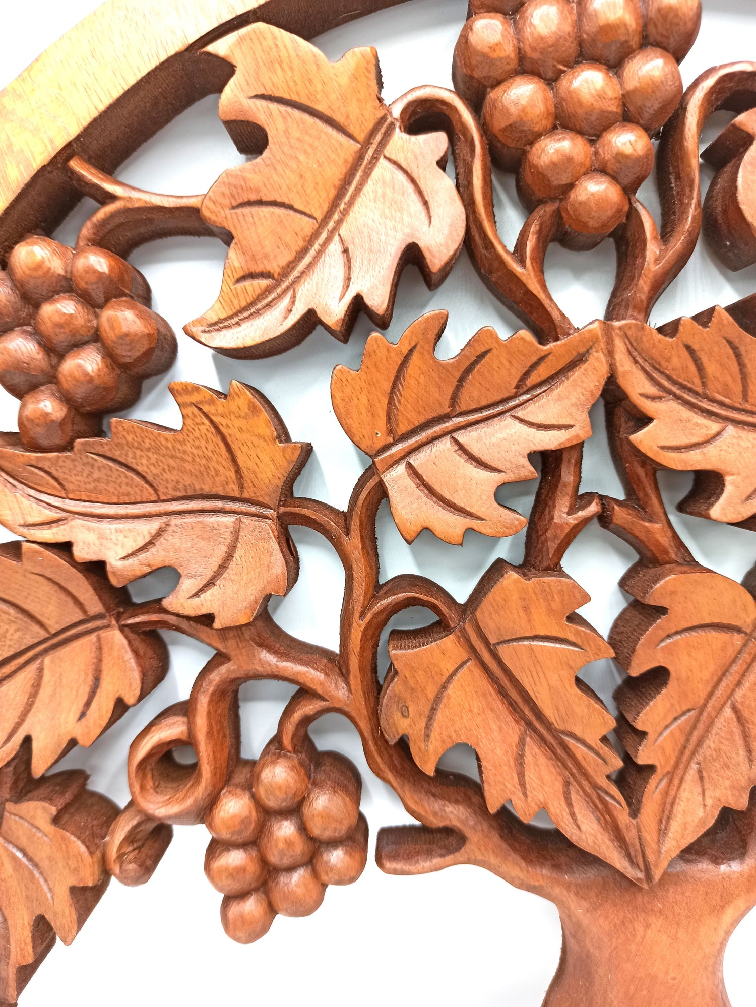 Wooden carving of leaves and grapes on a white background