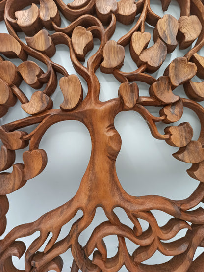 Wooden tree sculpture with intricate carvings on a light background
