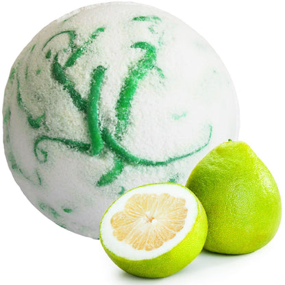 Bath bomb with green swirls next to a halved pomelo on a white background